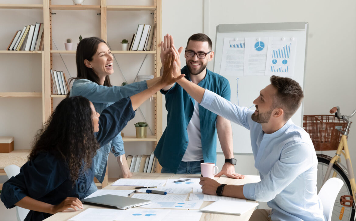 Overjoyed,Diverse,Businesspeople,Gather,In,Office,Gave,High,Five,Celebrate