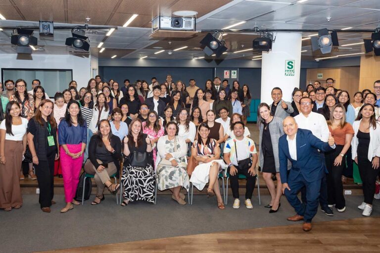 Grupo grande de mujeres y hombres en evento de capacitación